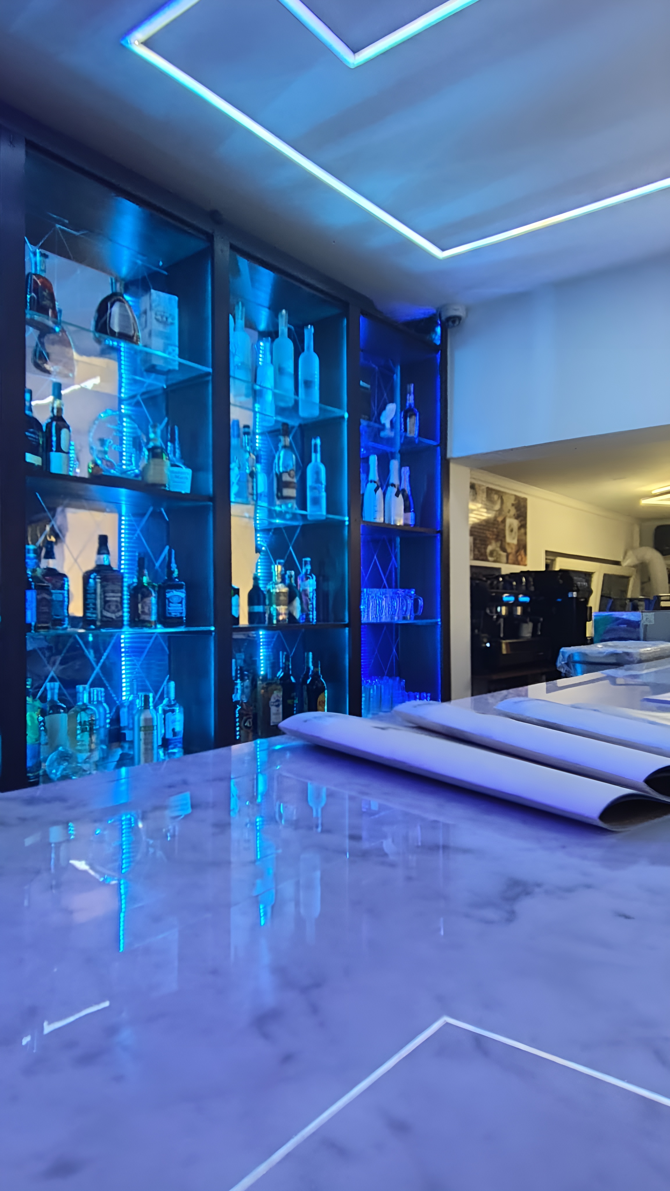 Bar mit Marmor-Tresen und beleuchteter Spirituosenwand